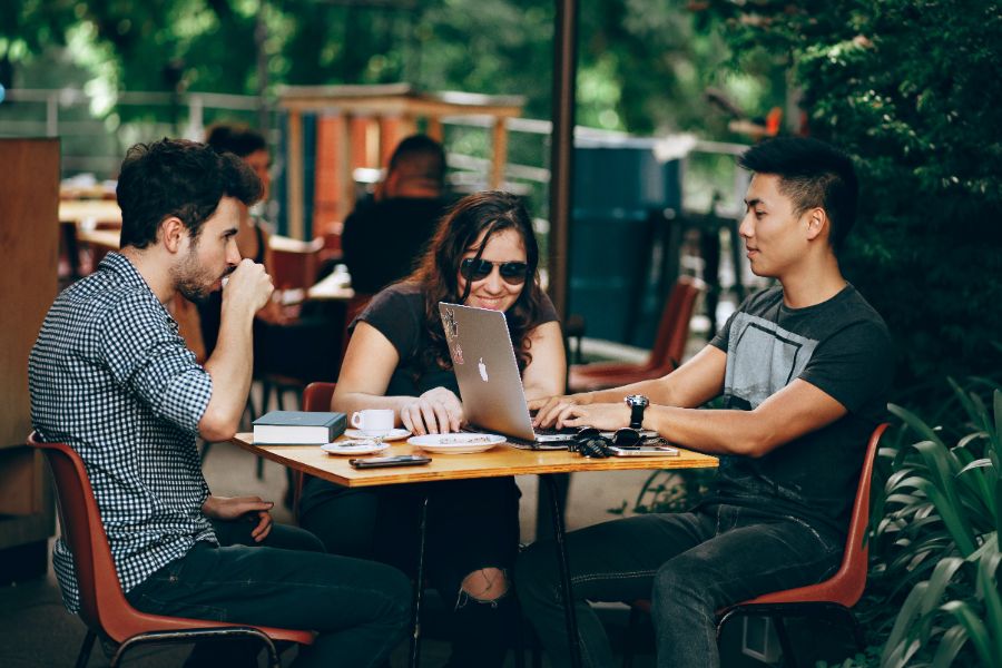 3 people having a work meeting with coffee outside.