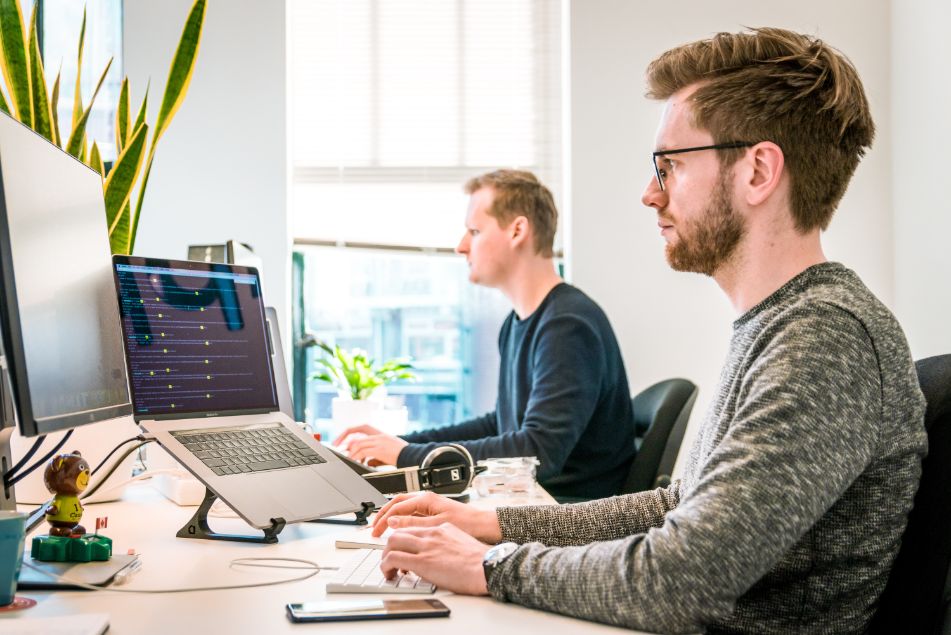 Two men sitting in front of their laptops