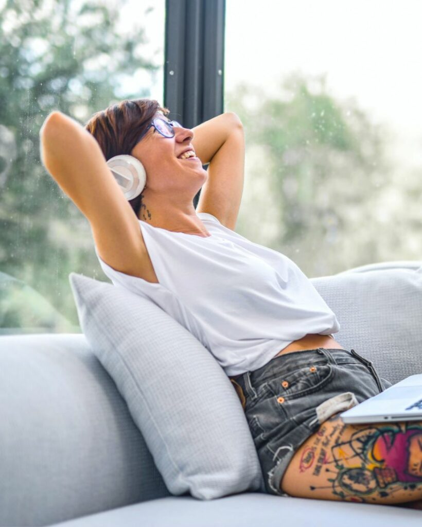 women sitting on the sofa leaning back with headphones